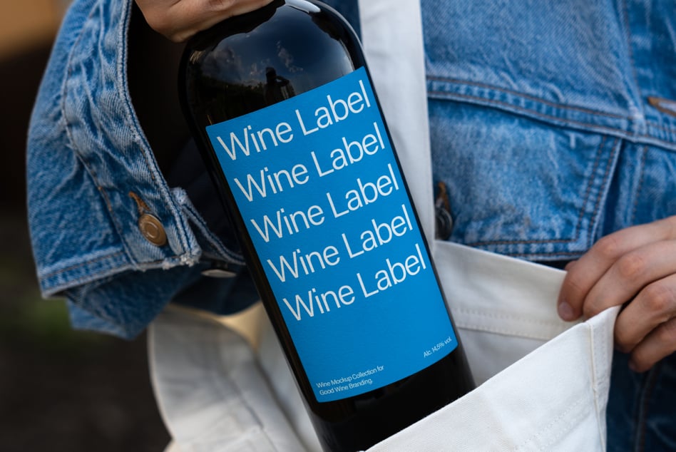 Wine bottle with bright blue label mockup in white bag with denim visible