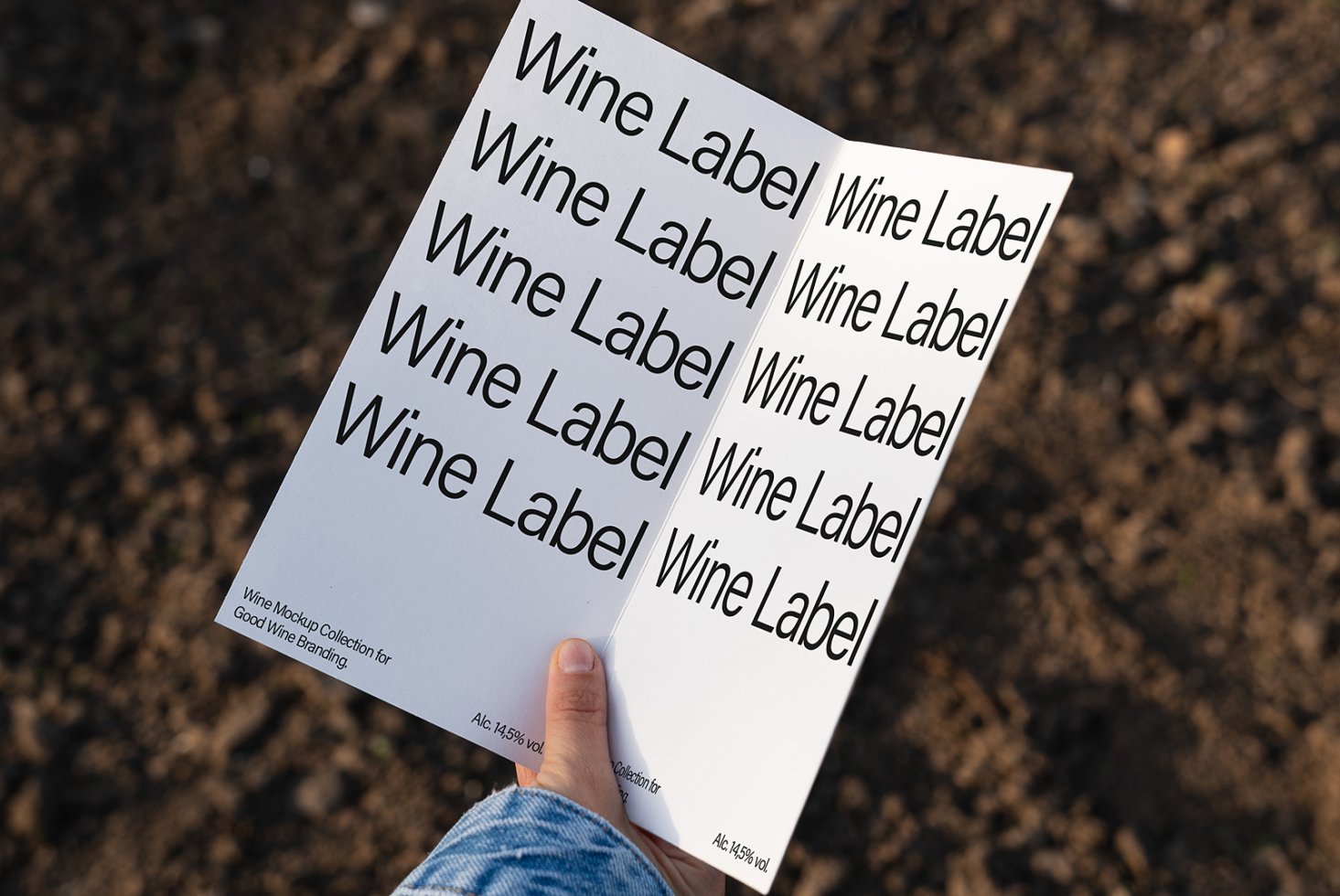 Wine label mockup with bold text on a folded page held outdoors. Perfect for branding and packaging design. Ideal for designers seeking templates.