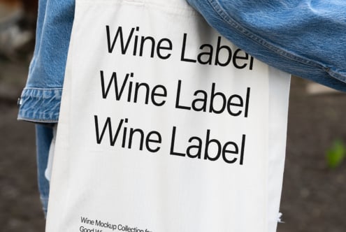 Canvas bag mockup with wine label design over a background. Ideal for showcasing branding, typography, fonts, and graphic design projects for designers.