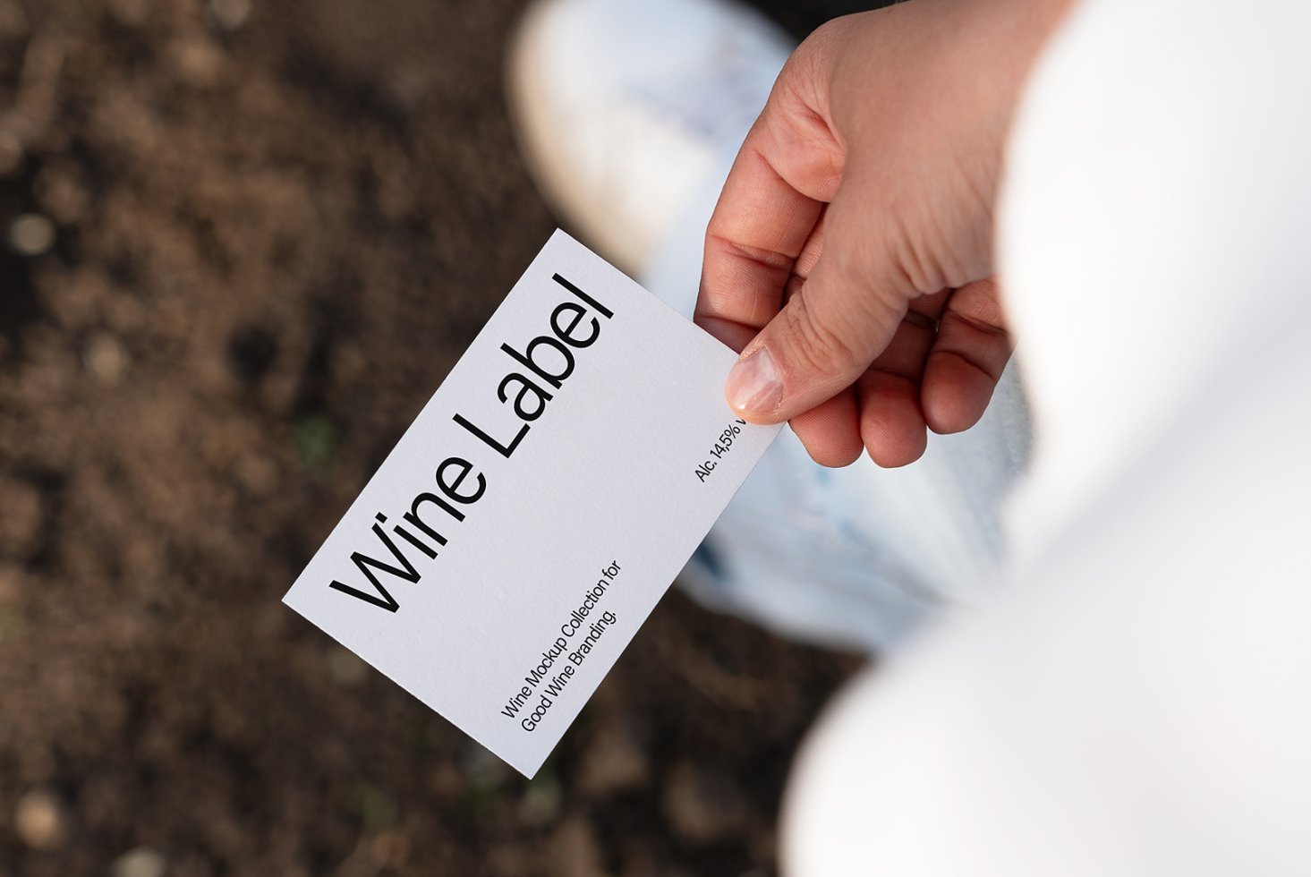 Hand holding a minimalist wine label card with text Wine Label 14.5 percent Alcohol. Ideal for designers seeking exclusive mockup graphics templates
