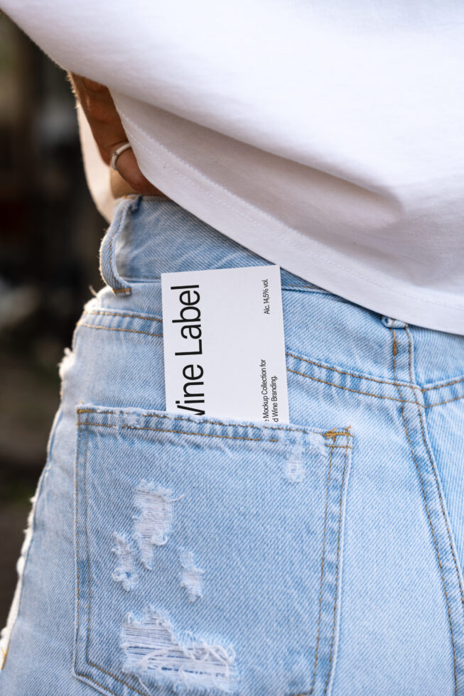 Wine label mockup in a pocket of ripped blue jeans. Ideal for branding projects. Image for designers on Marketplace. Keywords: Mockup, Jeans, Label.