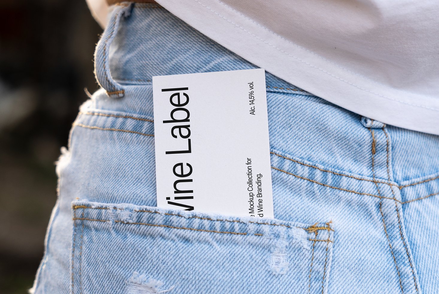 Wine label mockup in blue jeans pocket showcasing typography and branding design. Ideal for designers seeking realistic product presentation templates.