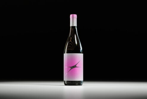 Elegant wine bottle mockup with pink label on dark background. Perfect for product presentation, branding, and packaging design. Ideal for designers.