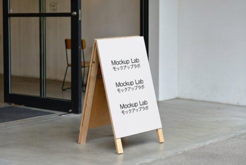 Wooden A-frame sign mockup with modern design placed outside a cafe entrance. Perfect for showcasing branding templates and marketing assets for designers.