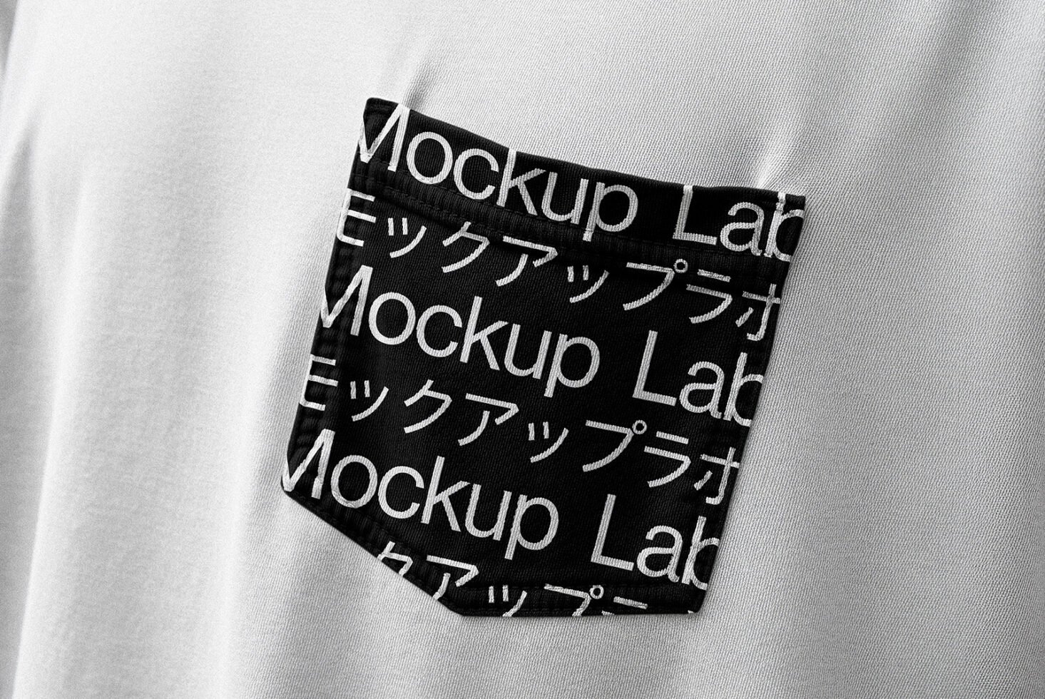 Close-up of white t-shirt with black pocket featuring modern typographic design Mockup Lab in English and Japanese. Ideal for fashion templates mockups.