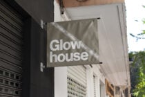 Taupe horizontal banner with Glow house in white letters on building