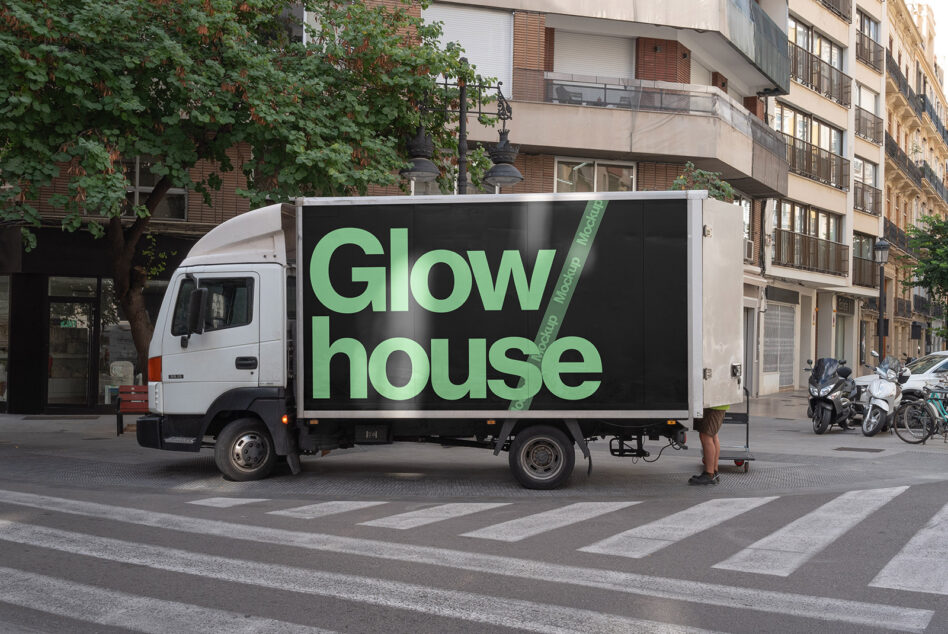 Lime green Glow house text on black truck side panel in urban street