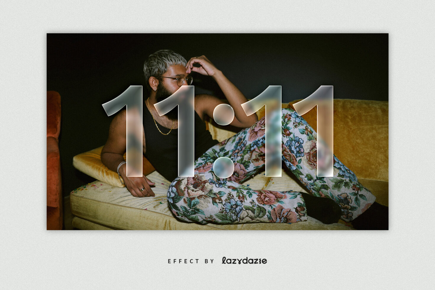 Fashionable man with floral pants on vintage couch gazing contemplatively. Overlay features 11:11 text in chrome effect. Perfect for graphic design mockups.