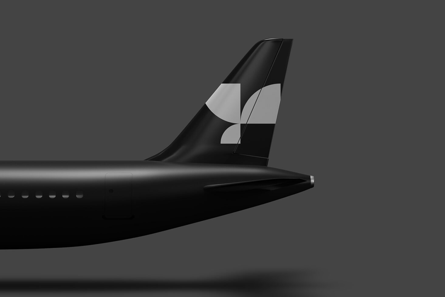 Mockup of airplane tail with sleek modern design featuring abstract white geometric logo on black background suitable for branding and design presentations.