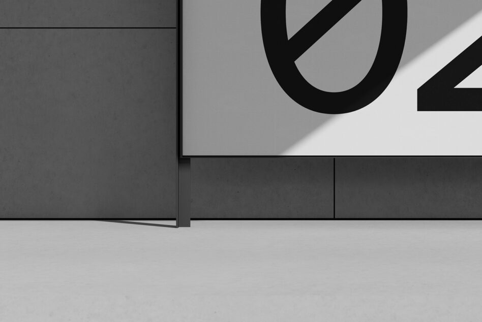Minimal poster mockup on concrete wall with bold black typography casting sharp shadows