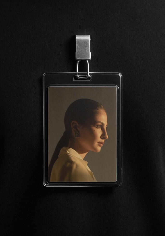ID card mockup featuring a portrait photo inside a plastic holder with a metal clip on a black fabric background ideal for designers branding projects