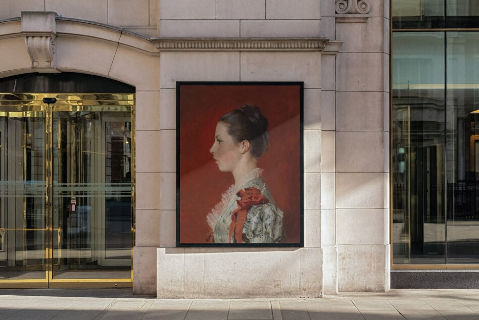 Framed portrait photograph mounted on downtown building exterior between storefronts