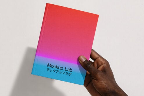 Hand holding vibrant gradient notebook cover with Mockup Lab text ideal for designers marketing templates mockups colorful graphics digital assets