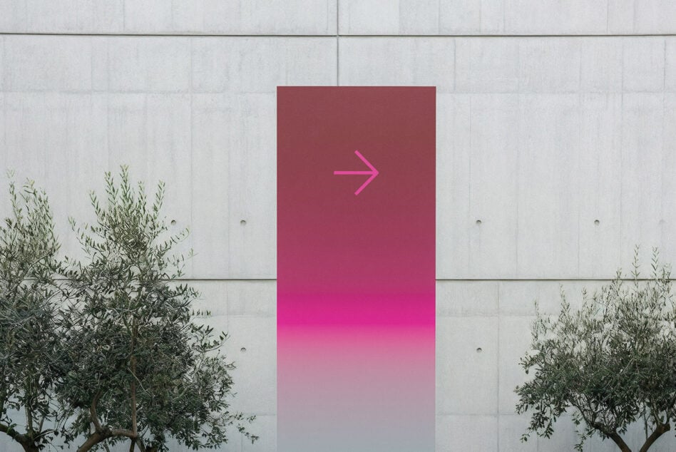 Pink gradient poster with neon arrow pointing right on concrete wall