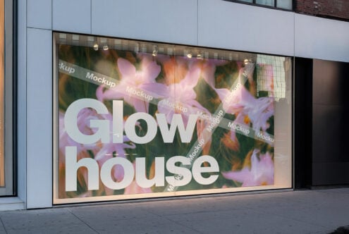 Storefront window display mockup featuring large text reading Glow House over a floral background ideal for showcasing retail or branding designs.