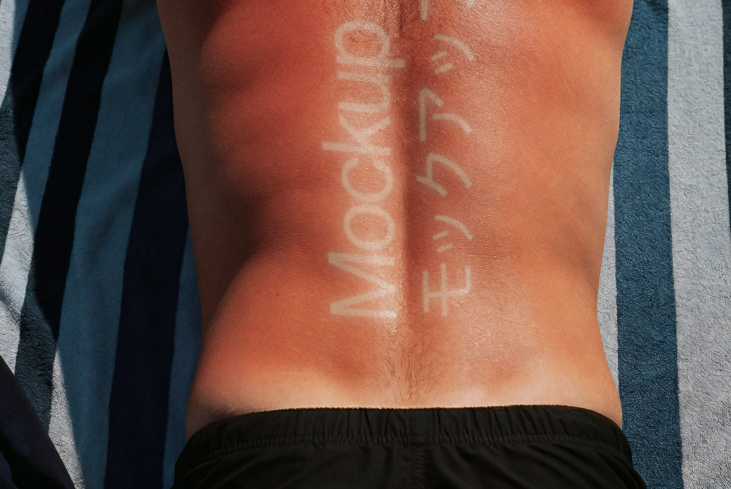 Tanned back with mockup text imprinted in white on striped towel background. Perfect for summer-themed design mockups, creative marketing, or sunbathing graphics.