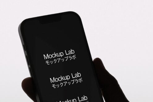 Black phone held up showing white screen with text on minimal background