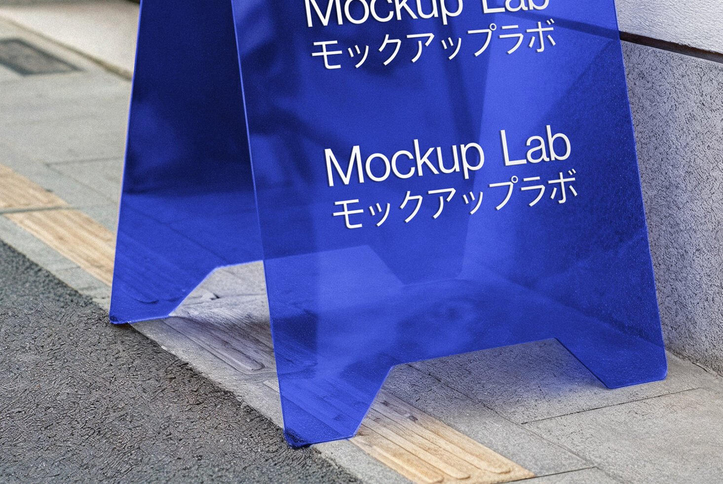 Blue transparent sidewalk sign mockup with text Mockup Lab in English and Japanese; perfect for graphic design templates and presentations