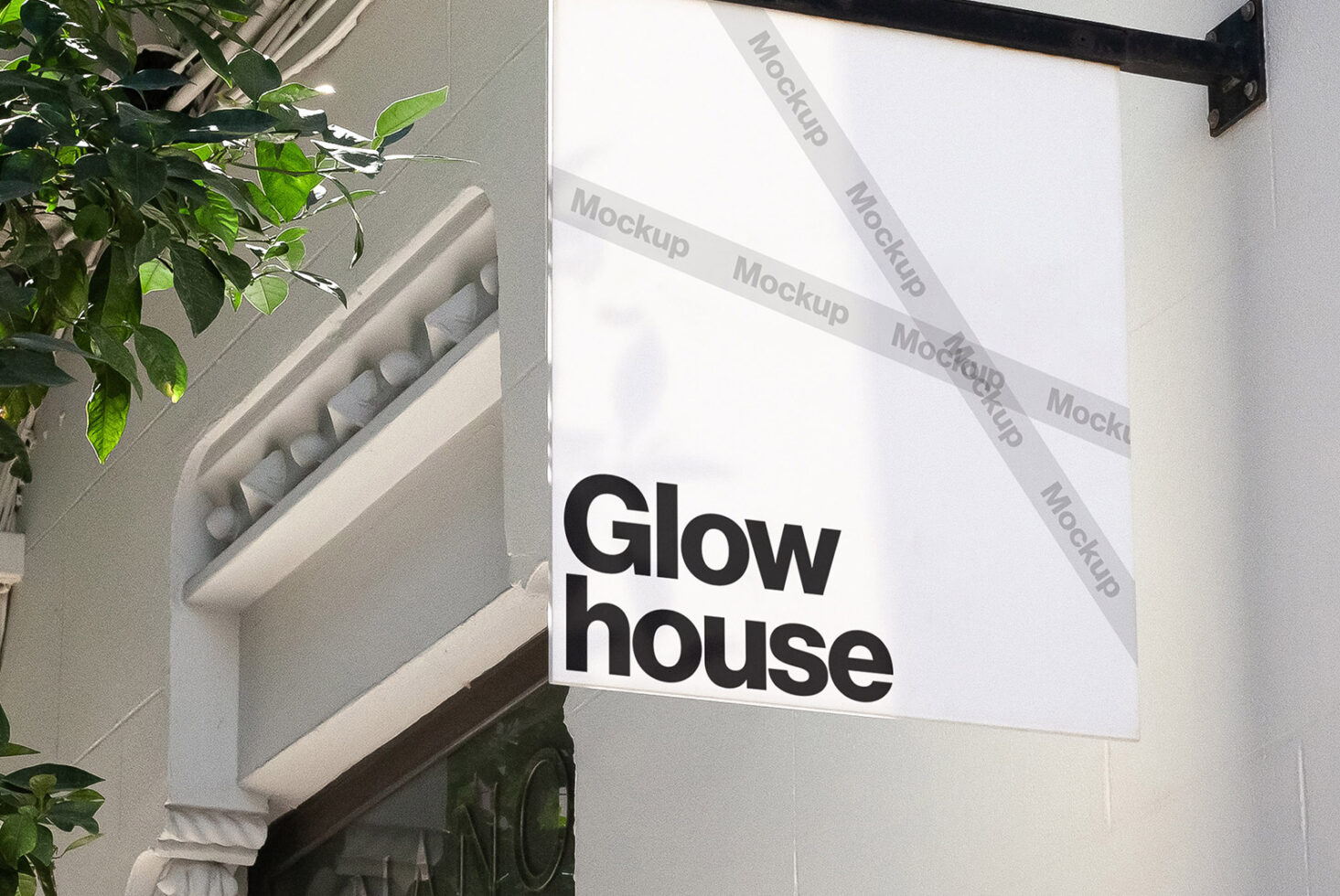 Outdoor signage mockup displaying Glow House text on a wall under leaves. Perfect for branding, graphic design, and template projects.