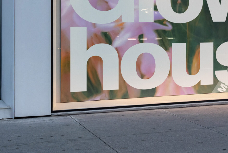 Storefront window with large cutout letters over blurred flower background