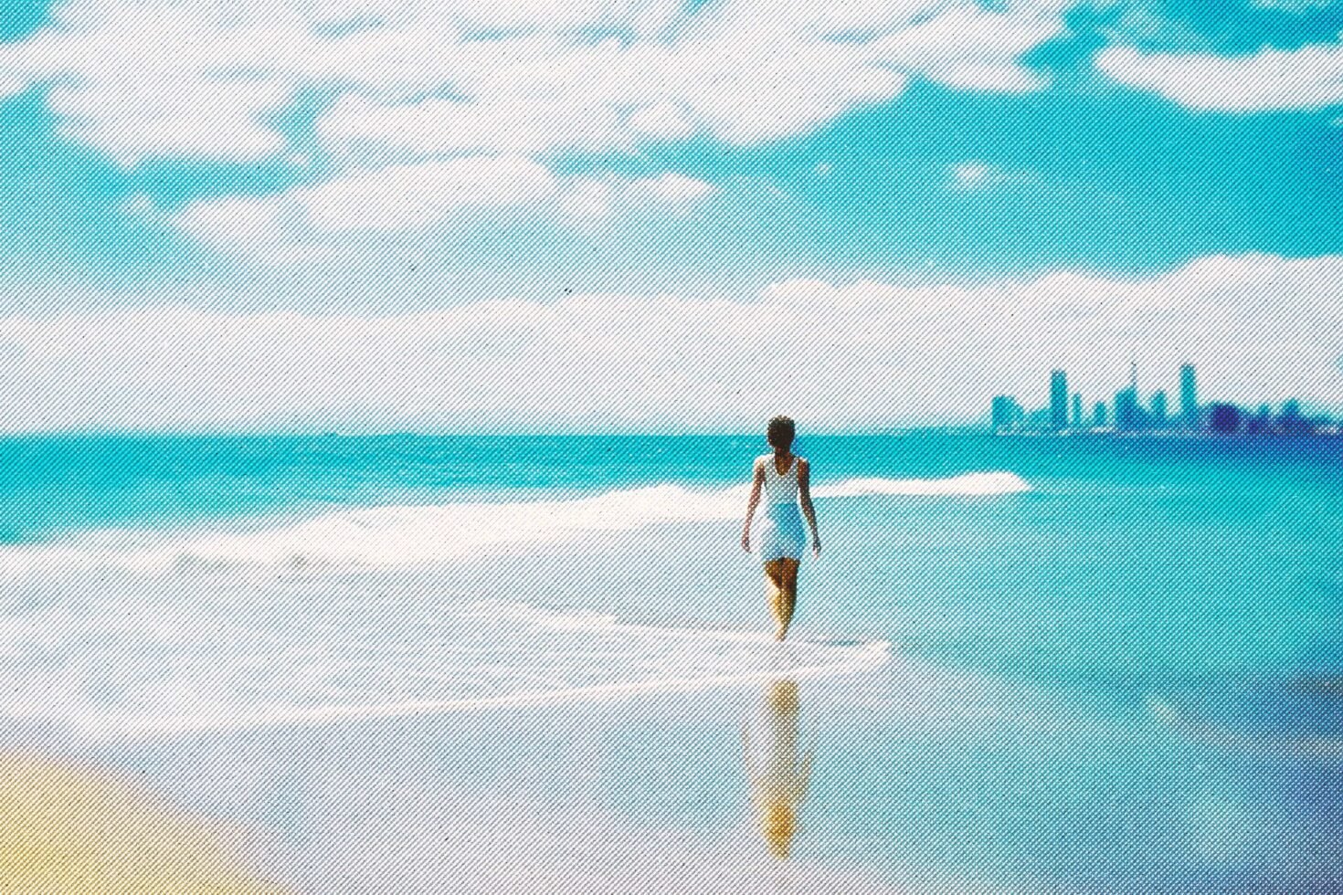 Woman in white dress walking on beach with city skyline background. Vibrant blue sea and sky reflecting in water. Ideal for graphics or template designs.