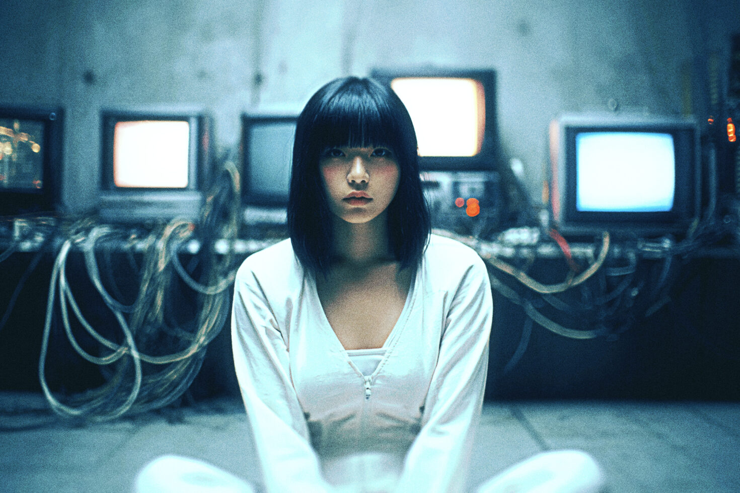Woman in white clothing sitting before retro monitors with cables, cyberpunk aesthetic, tech, digital art, vintage technology, design resource.
