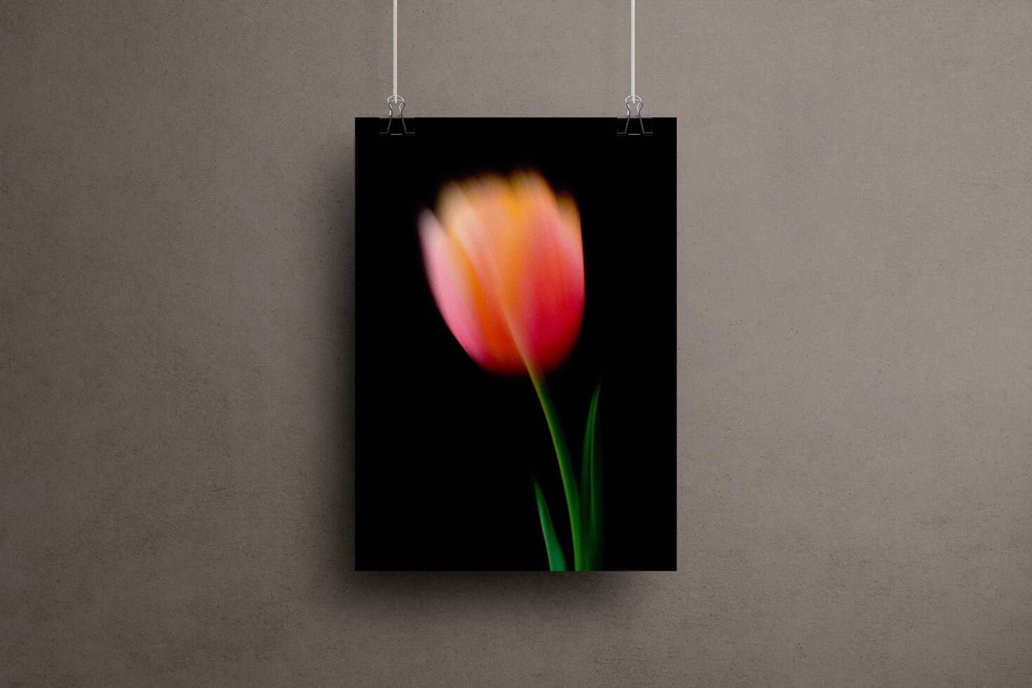 Blurred floral poster mockup with a pink tulip on a dark background hanging on a gray wall ideal for graphic design showcasing or templates.