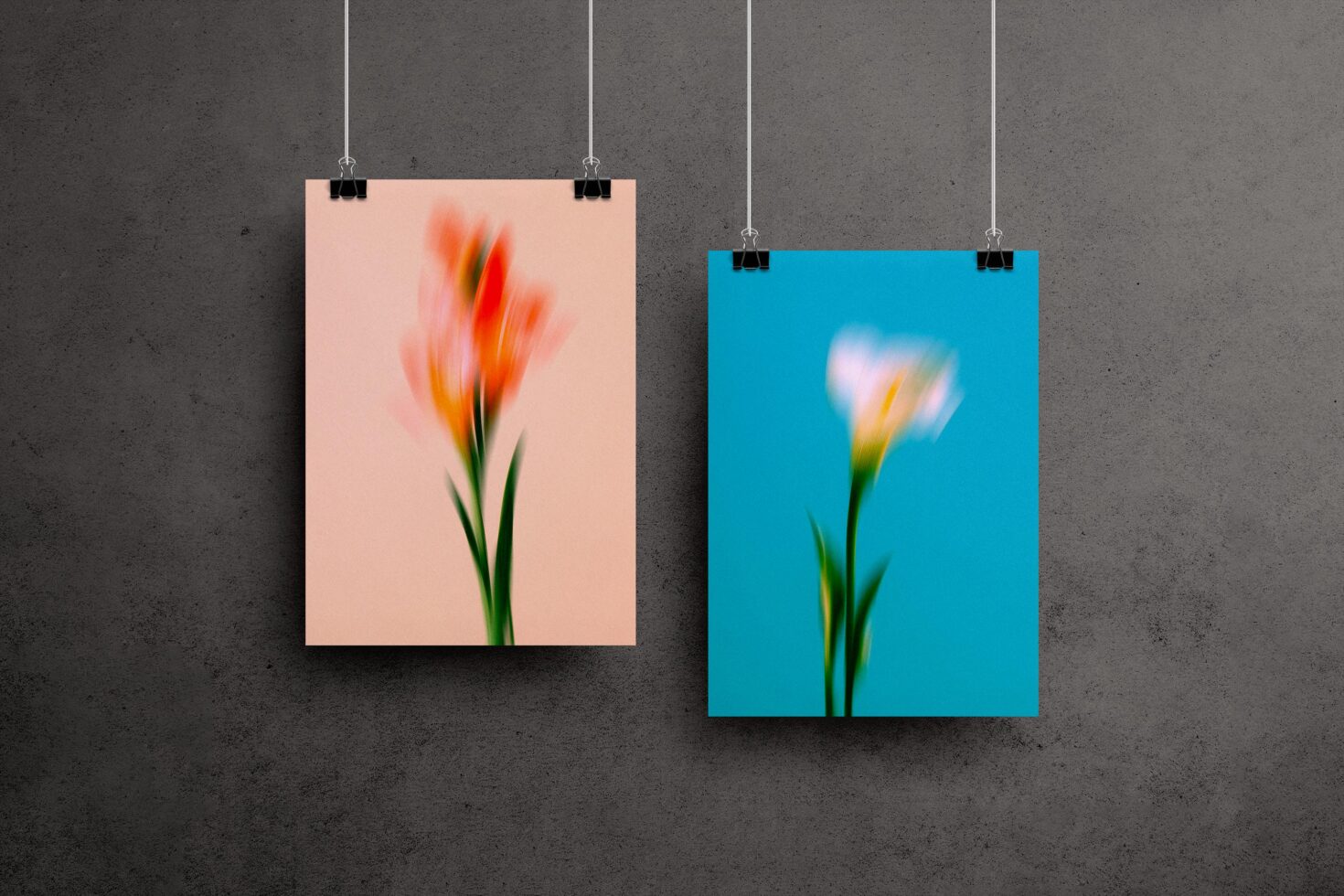 Two floral posters with blurred flowers in peach and blue color schemes hang on a textured wall. Ideal for mockups and graphic design inspiration.