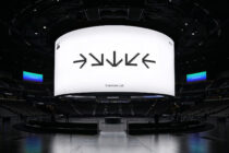 Stadium display screen with clean white background showing black pixelated text, minimal Colortime Lab text