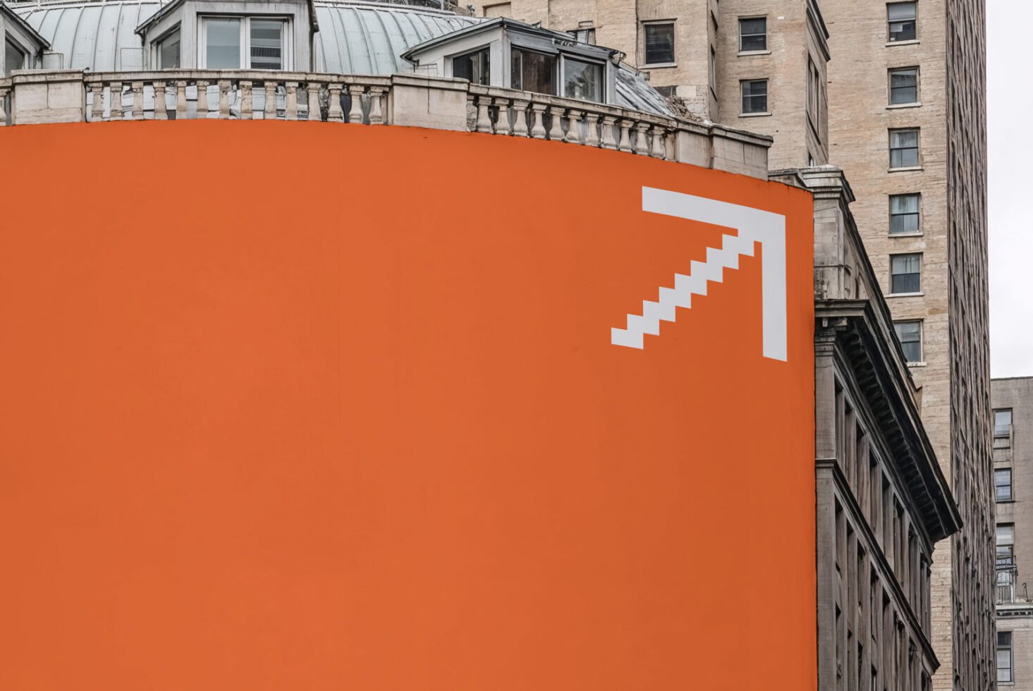Urban architecture featuring orange building facade with white stair pattern. Ideal for use in graphic design projects or as a cityscape template.