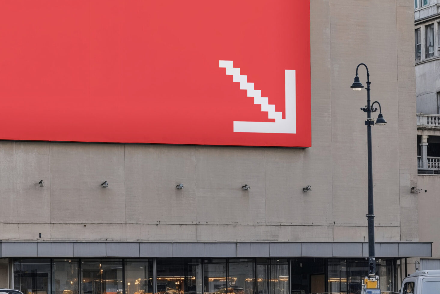 Large outdoor billboard mockup on urban street with bold red background and white stair-arrow graphic ideal for designers and advertising presentations.
