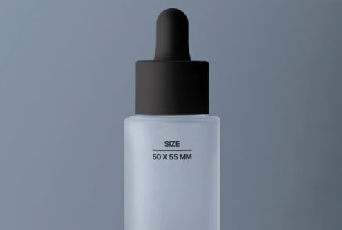 White dropper bottle with dark cap centered on soft blue backdrop
