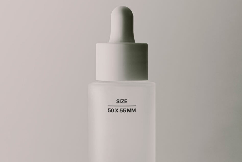 White dropper bottle with minimal cap stacked on pale background