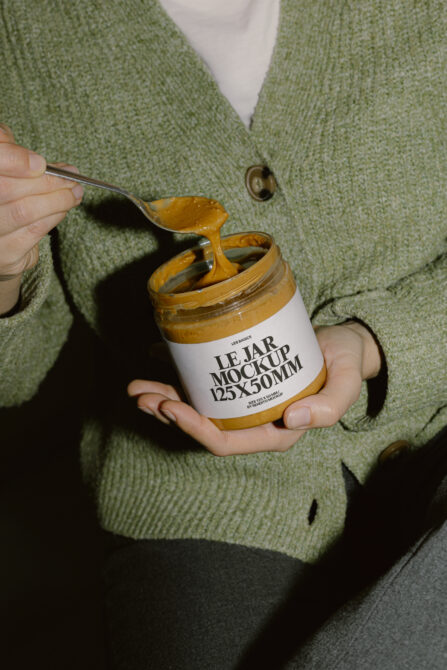 Jar mockup with mustard spread on spoon, model wearing sage green cardigan