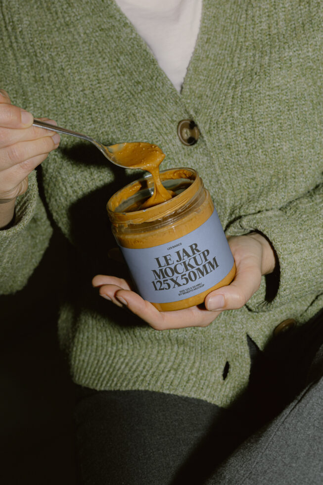 Jar mockup with mustard spread on spoon, model wearing sage green cardigan