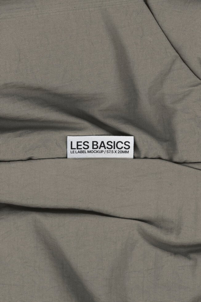 Les Basics woven label on rippled beige fabric background