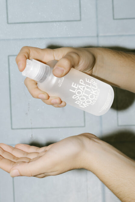 Hand holding white bottle with label text above open palm indoors