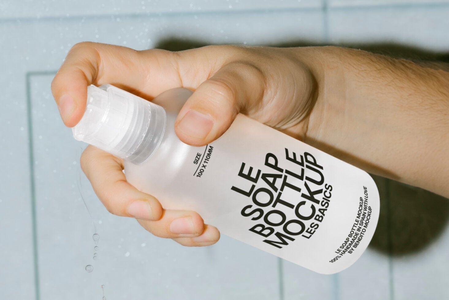 Person squeezing clear liquid from white bottle into cupped hand