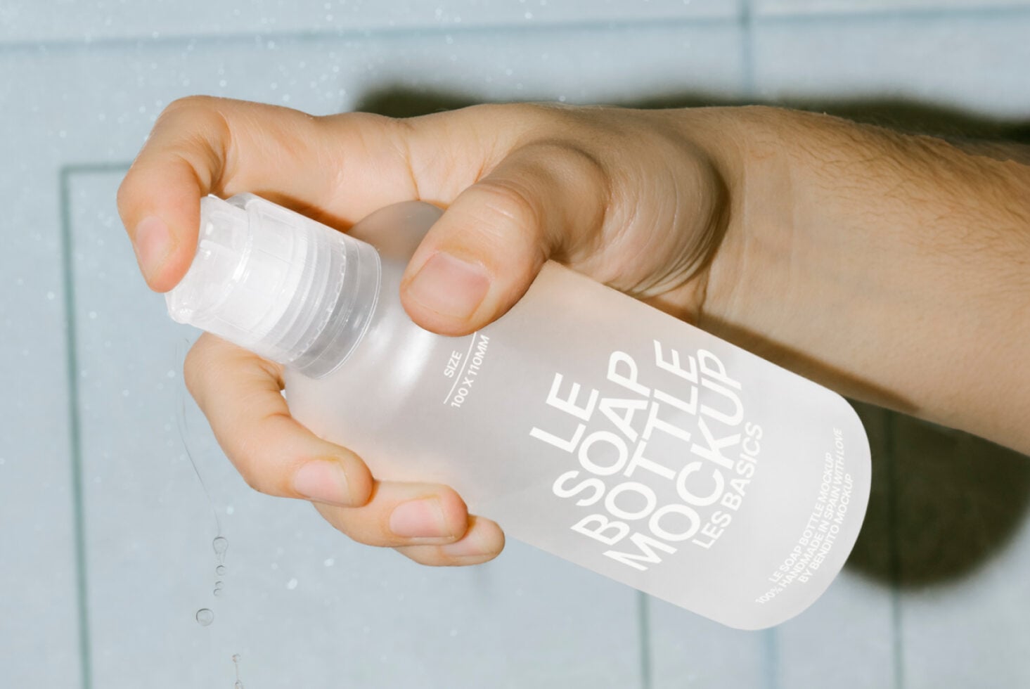 Close-up of hands dispensing product from white bottle in bright setting