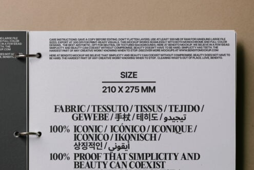 Opened care instruction tag with multilingual fabric content labels on kraft paper