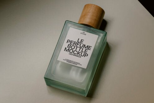 Perfume bottle mockup with wooden cap on table. High-quality design resource for branding and product presentation. Ideal for templates and graphics.