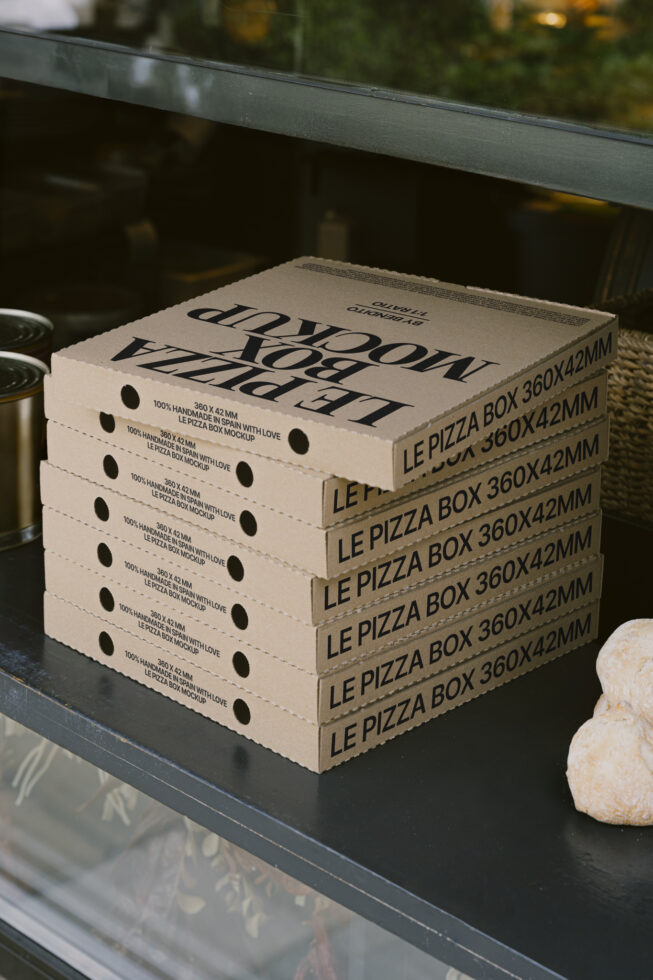 Stack of pizza box mockups with text Le Pizza Box on a counter suitable for packaging design. Ideal for templates and graphics in food-related projects.