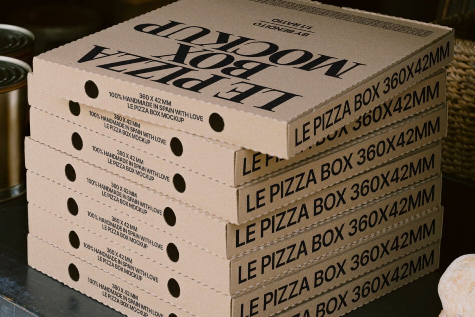Stacked pizza boxes with handmade branding, serif typography, kraft paper