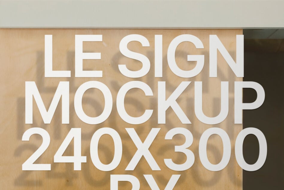 White cut-out lettering spelling LE SIGN MOCKUP 240X300 on natural wood texture background