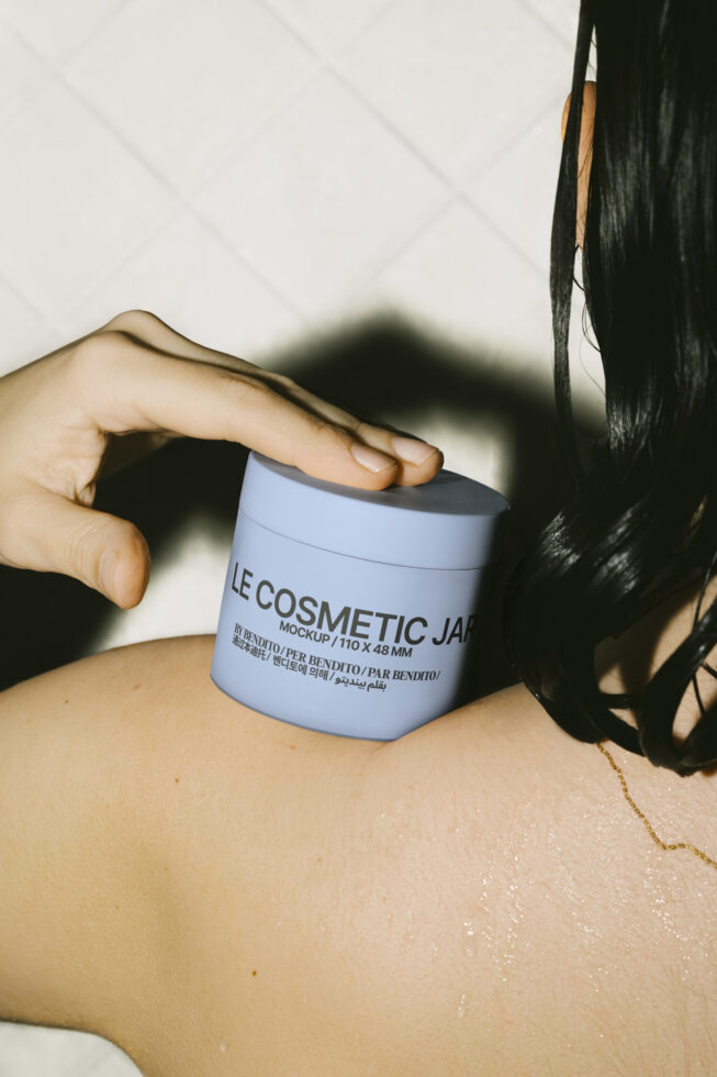 Mockup of a blue cosmetic jar held on a woman's wet shoulder, featuring design details and dimensions. Ideal for designers creating beauty product presentations.