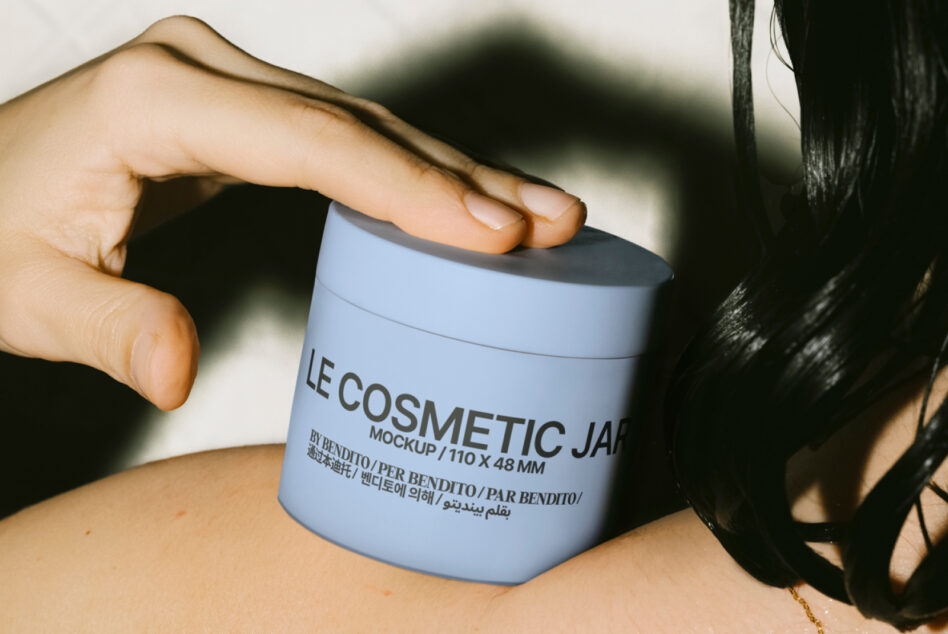 Blue cosmetic jar mockup held in hand with dramatic shadow, close up