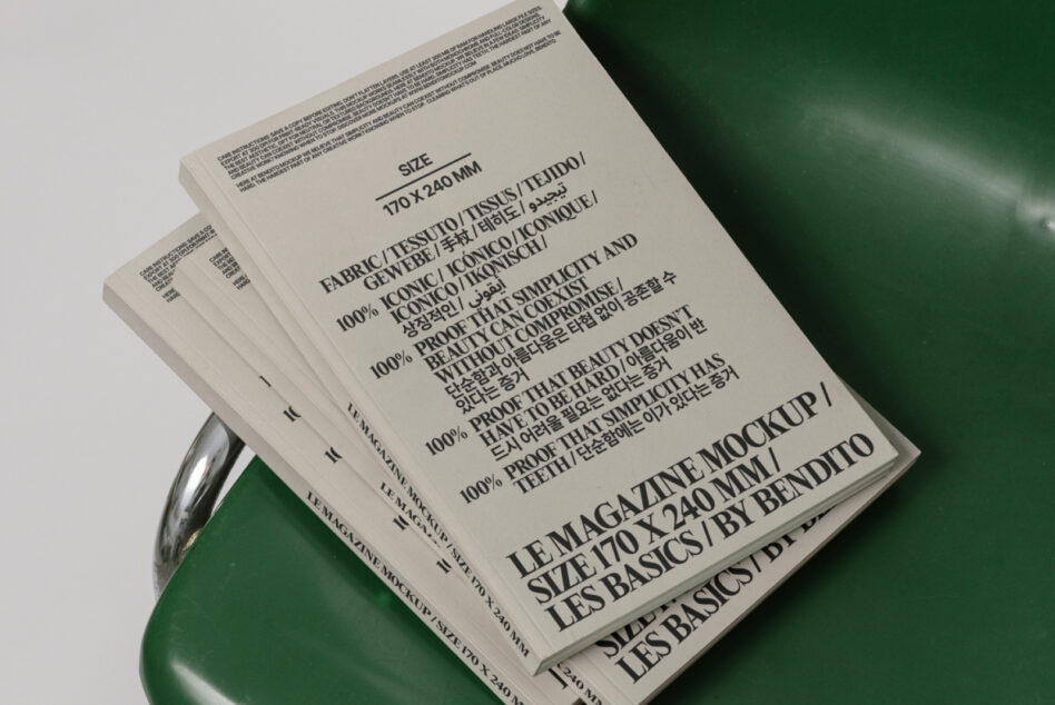 Stacked magazines with cream pages on green sculptural chair angled view