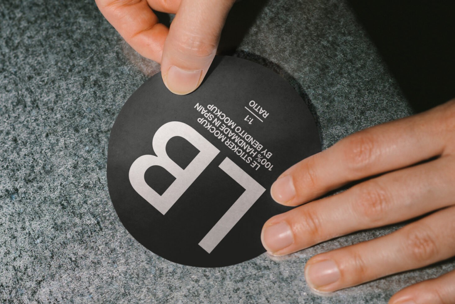 Round sticker mockup with hands on textured surface. Ideal for branding and design presentations. High-resolution attachment for graphic designers.