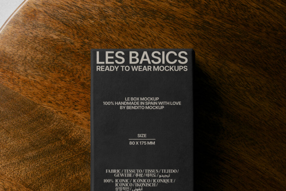 Dark box mockup on wood grain table, Les Basics branding on front visible