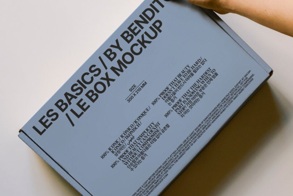 Overhead shot of blue box mockup held in hands, showing angled perspective